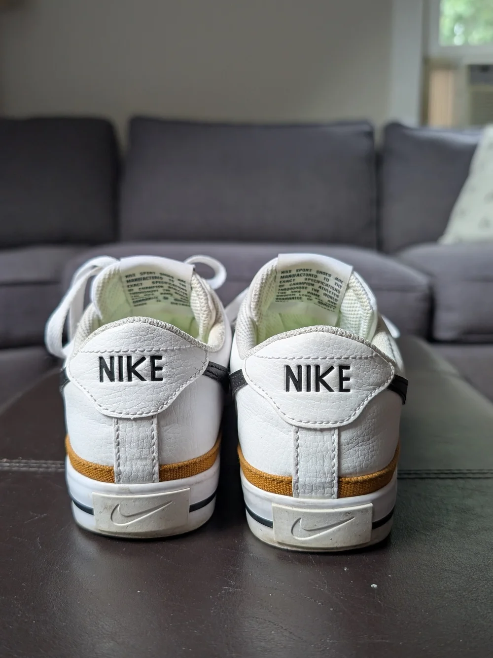 Nike Women’s White Sneakers with Black Swoosh and Gold Trim